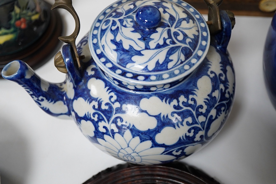 An 18th century Chinese blue and white dish, two jars (one without cover), a teapot and two carved wooden stands